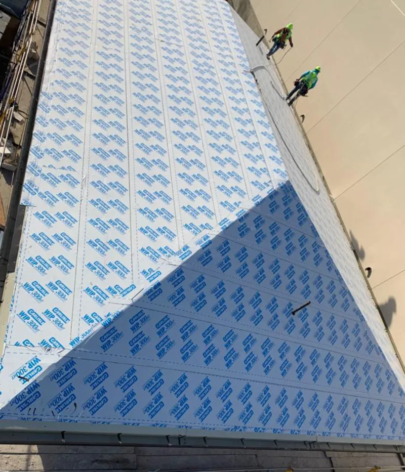 Professional roofers installing underlayment on a metal roof in Southport